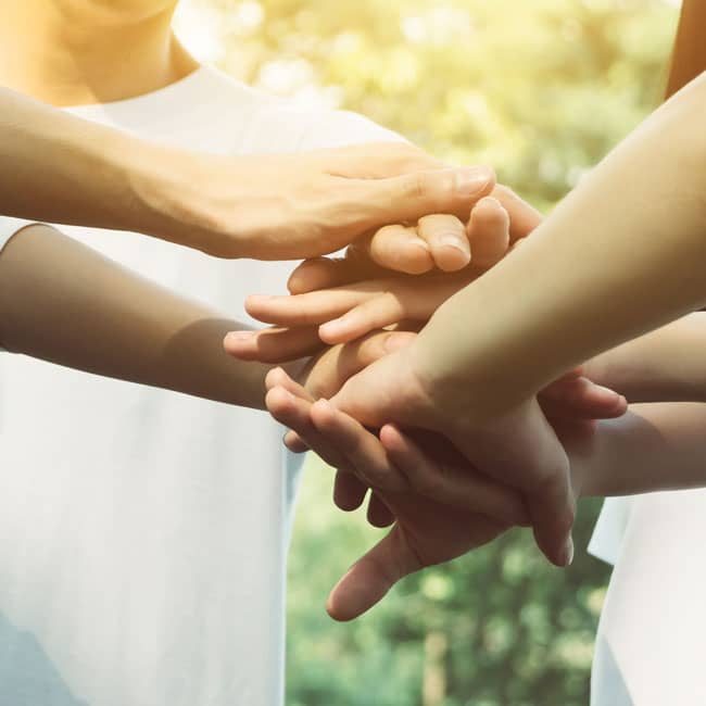 Group of people placing hands on top of each other