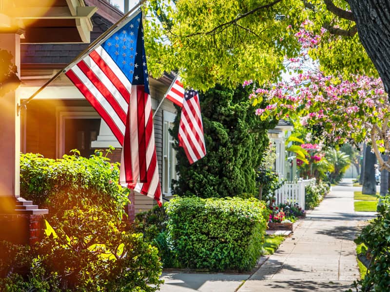 Quiet neighborhood street with American flags hanging prominently